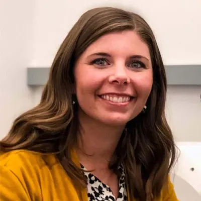 Elise Cope headshot in a yellow shirt